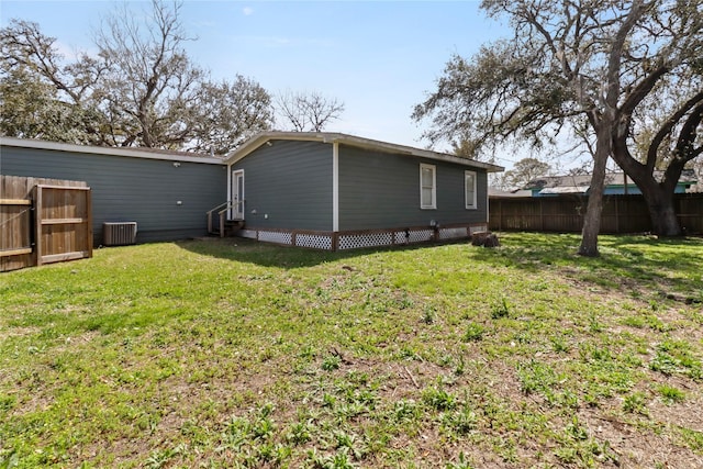 back of house featuring a yard, entry steps, central AC unit, and fence