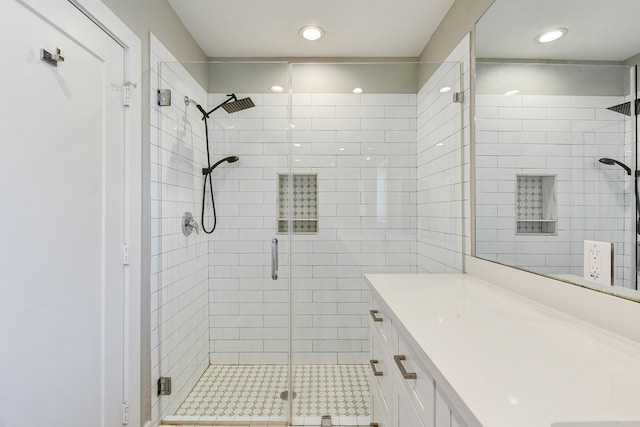 bathroom with vanity, a shower stall, and recessed lighting