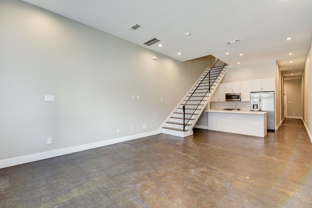 unfurnished living room with visible vents, stairs, concrete flooring, and baseboards