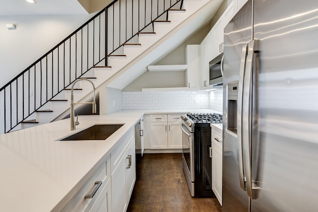 kitchen with a sink, backsplash, stainless steel appliances, white cabinets, and light countertops