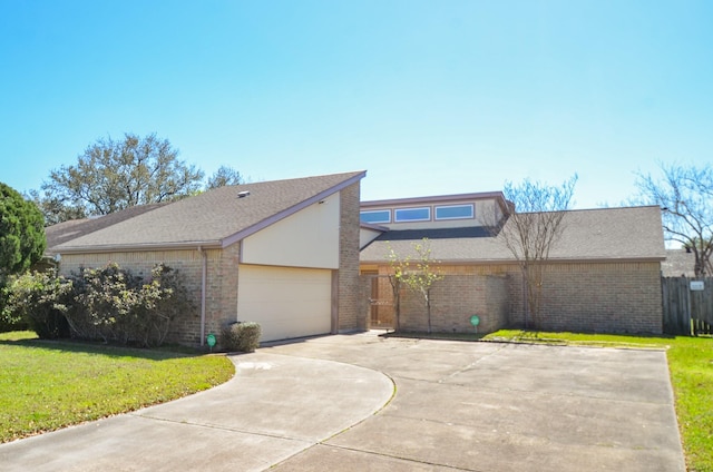 mid-century modern home featuring driveway, brick siding, a front yard, and fence