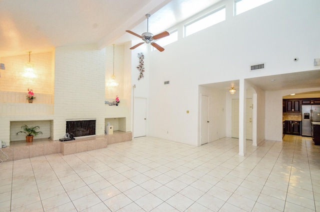 unfurnished living room featuring light tile patterned floors, visible vents, ceiling fan, and a fireplace