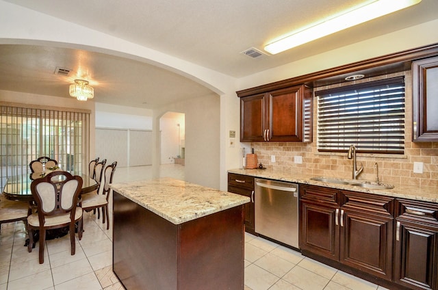 kitchen featuring visible vents, a kitchen island, a sink, decorative backsplash, and dishwasher