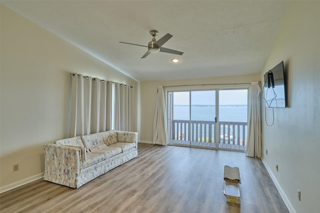 unfurnished living room with baseboards, wood finished floors, ceiling fan, and vaulted ceiling