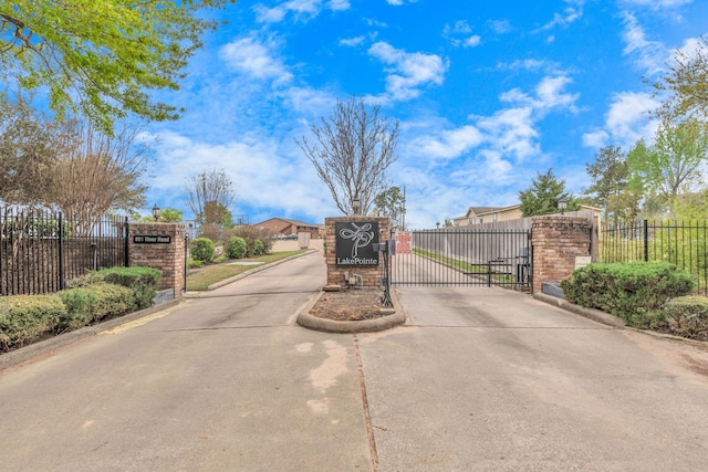 view of road featuring a gate, curbs, and a gated entry