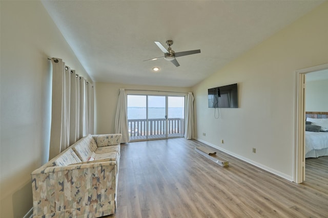 unfurnished room with vaulted ceiling, wood finished floors, a ceiling fan, and baseboards