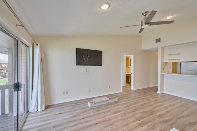 unfurnished living room featuring visible vents, ceiling fan, baseboards, lofted ceiling, and light wood-style floors