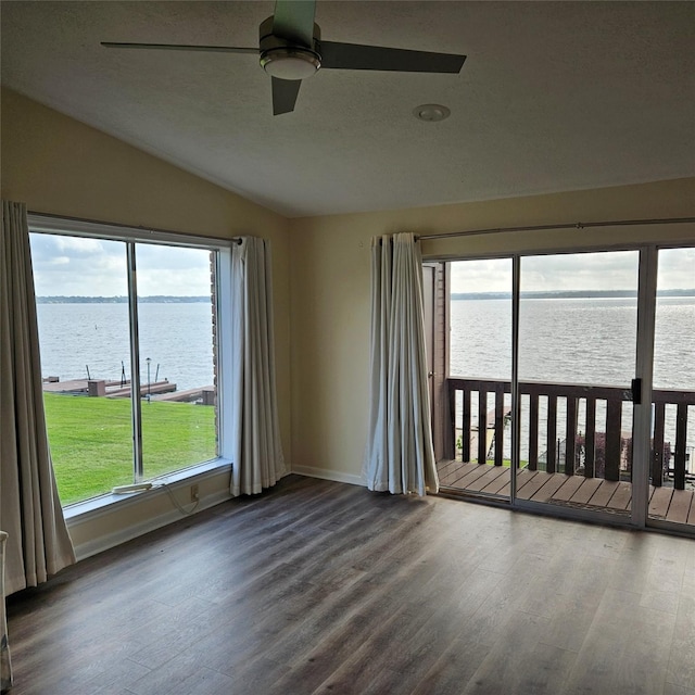 801 River Rd Unit 102C, Montgomery, TX 77356 - empty room featuring a water view, vaulted ceiling, a ceiling fan, and wood finished floors