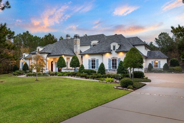 26009 Crown Ranch Blvd, Montgomery, TX 77316 - french country style house featuring a yard, driveway, a chimney, and stucco siding