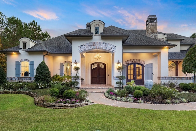 26009 Crown Ranch Blvd, Montgomery, TX 77316 - exterior space with roof with shingles, stucco siding, a chimney, french doors, and a yard