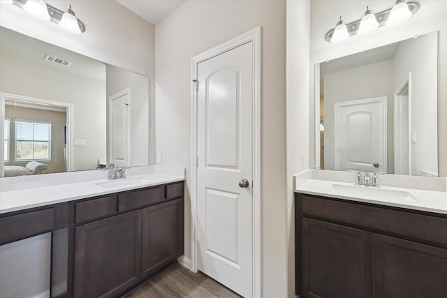 full bathroom featuring visible vents, connected bathroom, vanity, and wood finished floors