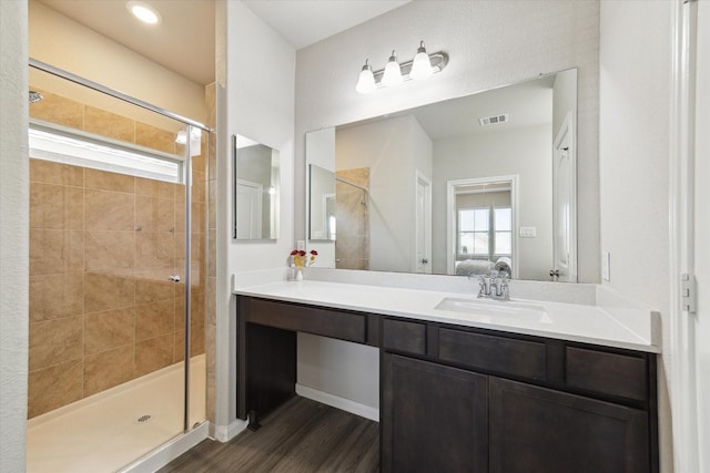 bathroom with visible vents, a shower stall, connected bathroom, wood finished floors, and vanity