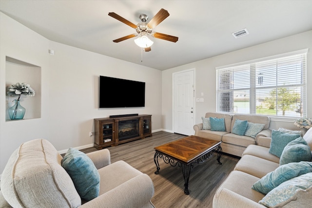 living area featuring visible vents, baseboards, wood finished floors, and a ceiling fan