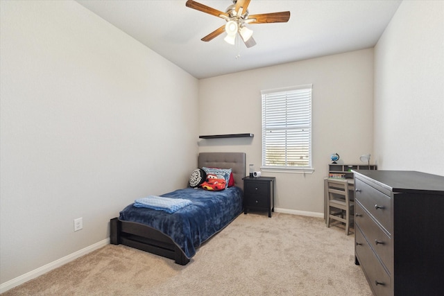 bedroom featuring light colored carpet, baseboards, and ceiling fan