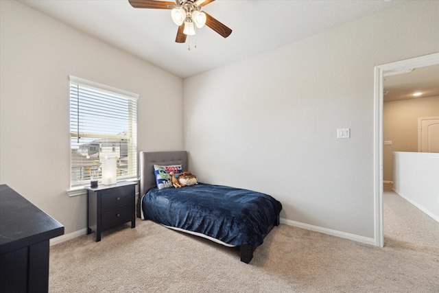 bedroom with a ceiling fan, baseboards, and light carpet