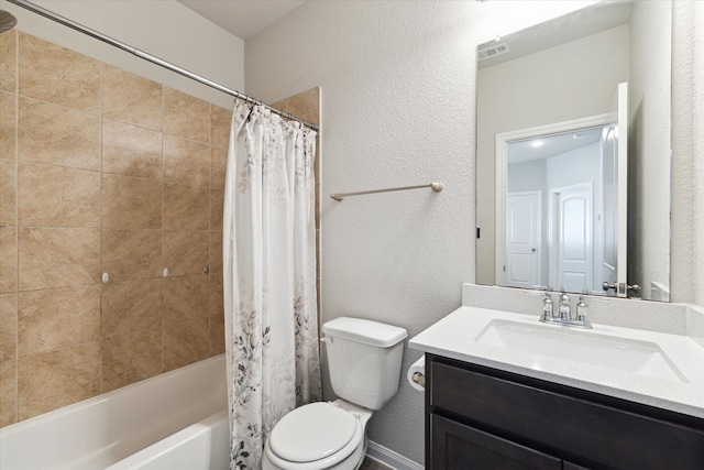 full bath with visible vents, toilet, shower / tub combo, vanity, and a textured wall