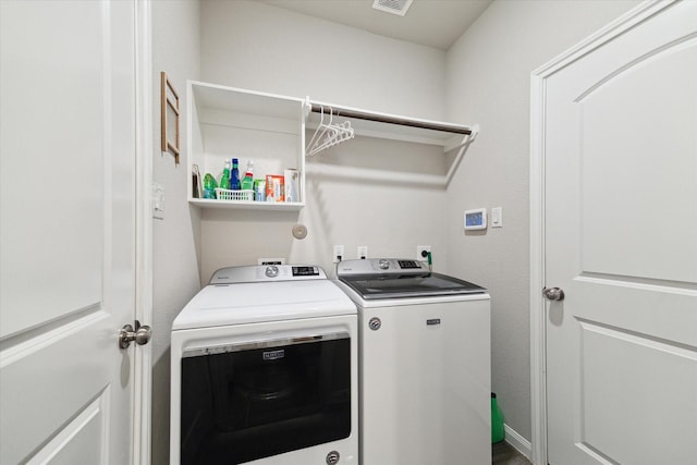 washroom with visible vents, laundry area, and washer and clothes dryer