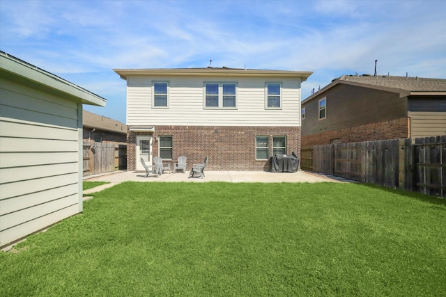 rear view of property featuring a patio area, brick siding, a fenced backyard, and a lawn