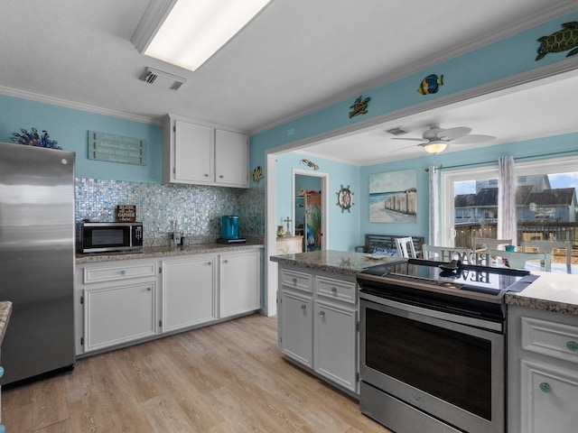 kitchen featuring backsplash, stainless steel appliances, light wood-style floors, white cabinets, and crown molding