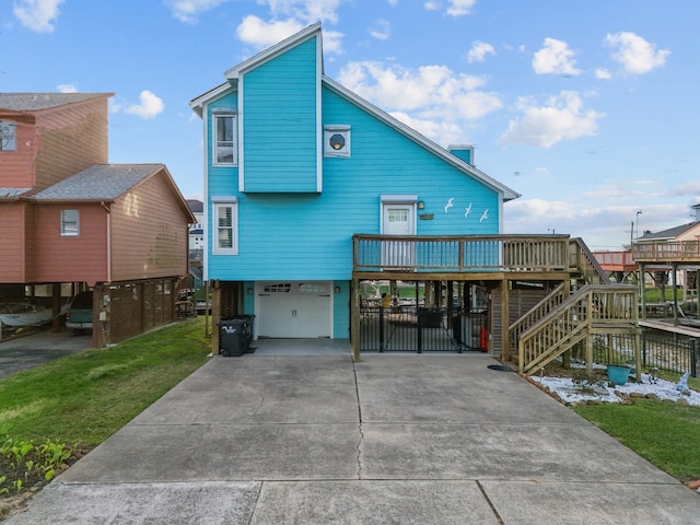 back of property with a yard, stairway, concrete driveway, an attached garage, and a carport