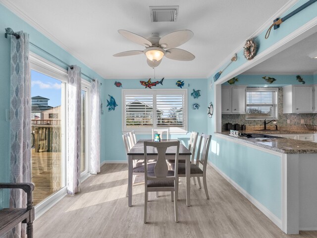 dining room featuring light wood-style floors, visible vents, and a wealth of natural light