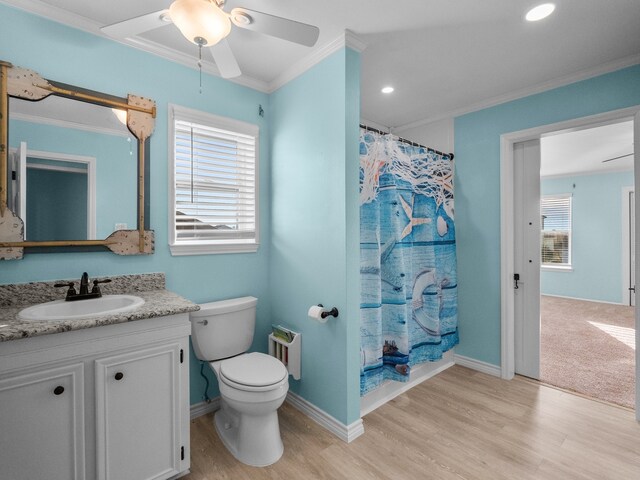 full bath with toilet, ornamental molding, baseboards, ceiling fan, and vanity