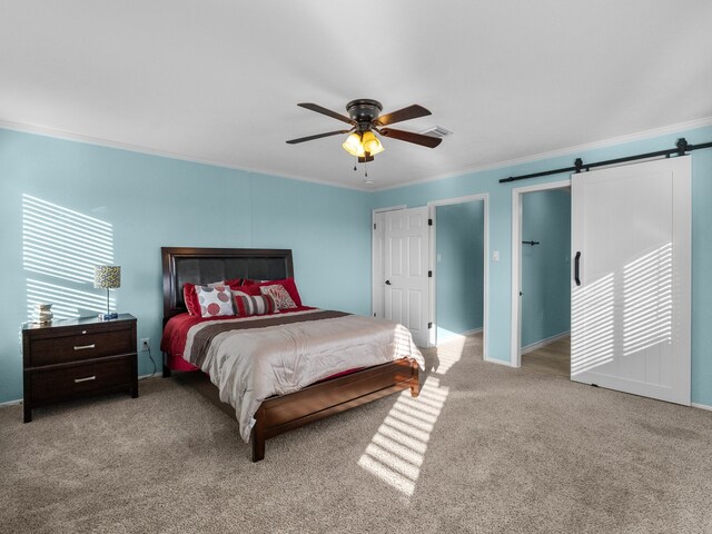 bedroom featuring visible vents, carpet flooring, crown molding, and a barn door