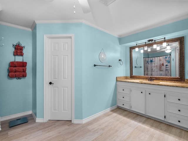 bathroom with baseboards, wood finished floors, and ornamental molding