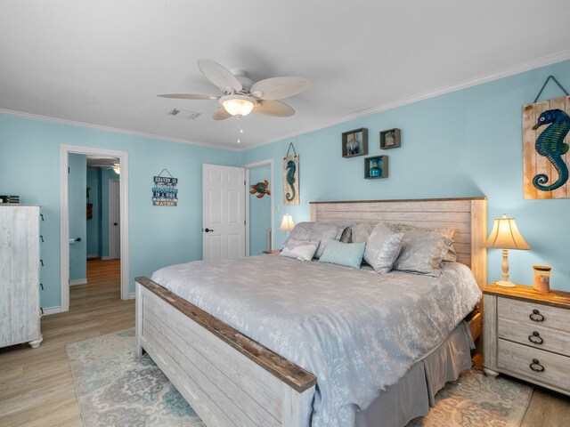 bedroom with visible vents, baseboards, ornamental molding, light wood-style flooring, and a ceiling fan