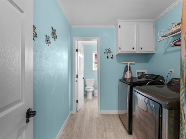 clothes washing area featuring ornamental molding, cabinet space, light wood-style floors, separate washer and dryer, and baseboards