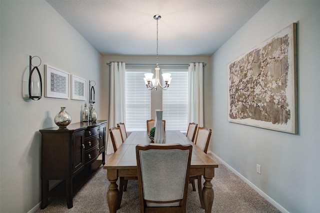 dining space with baseboards, carpet, and a chandelier