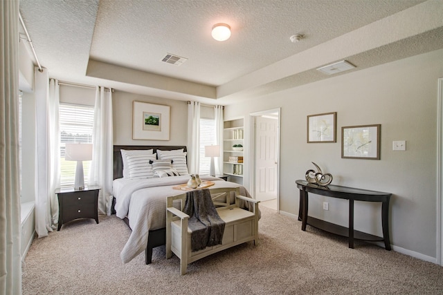 bedroom with visible vents, baseboards, carpet, and a textured ceiling