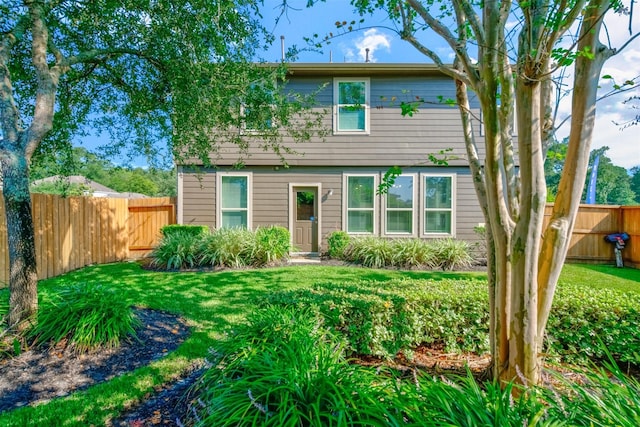 colonial-style house with a front lawn and fence