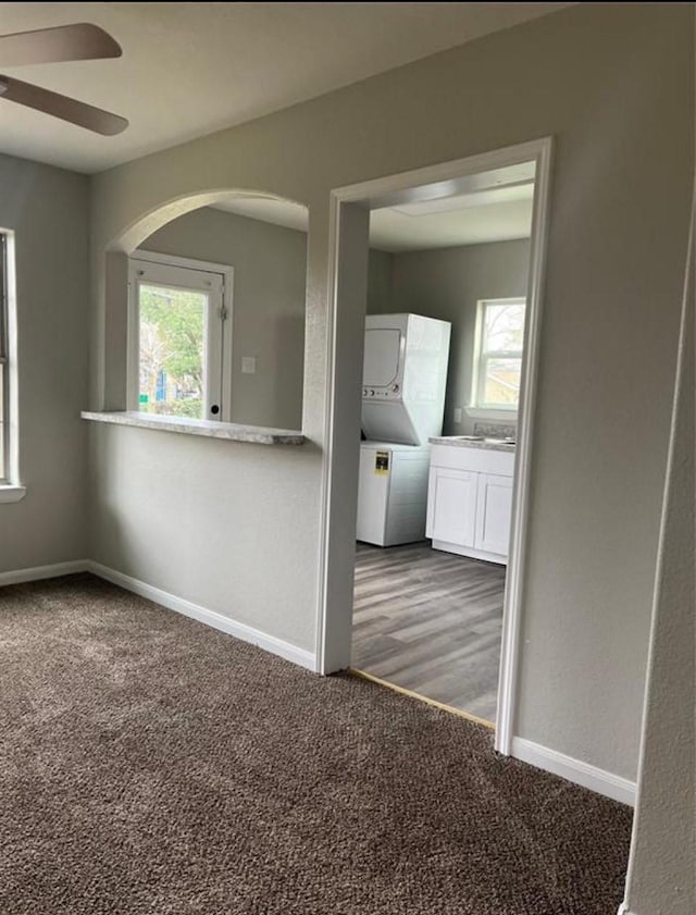 empty room featuring a ceiling fan, plenty of natural light, carpet, and baseboards