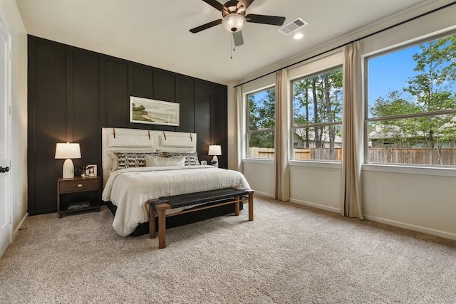 bedroom with a ceiling fan, light colored carpet, visible vents, and baseboards