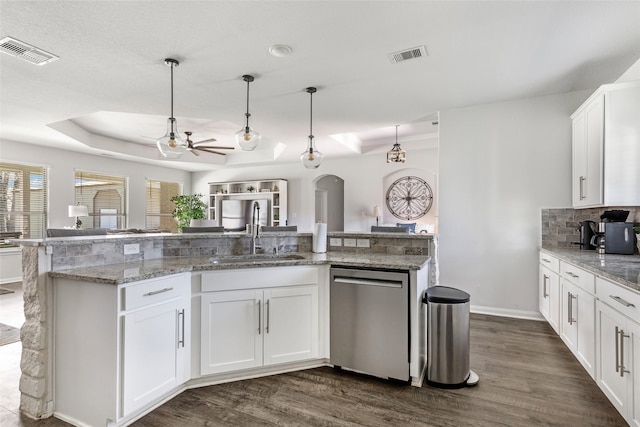 kitchen with dishwasher, a raised ceiling, visible vents, and a sink