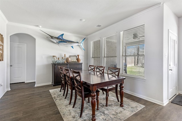 dining room featuring dark wood finished floors, visible vents, arched walkways, and baseboards