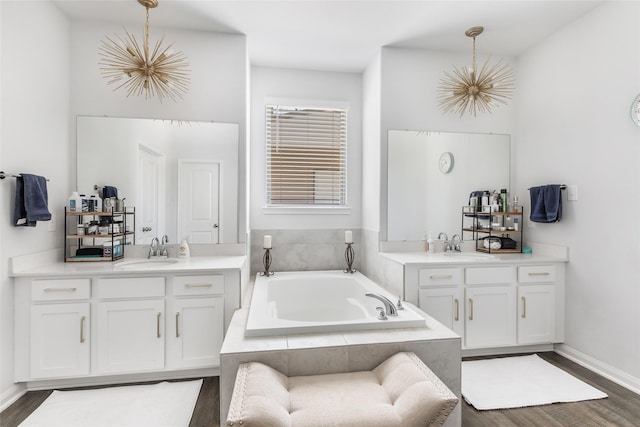 full bathroom featuring a sink, two vanities, and wood finished floors