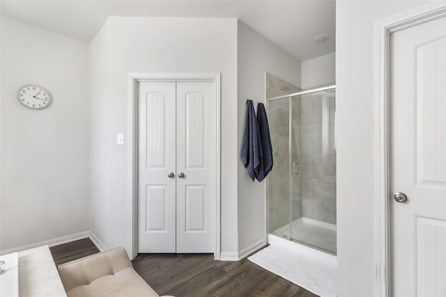 full bathroom featuring wood finished floors, a stall shower, and baseboards