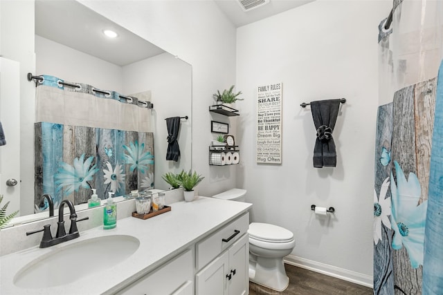 bathroom featuring vanity, a shower with shower curtain, wood finished floors, baseboards, and toilet