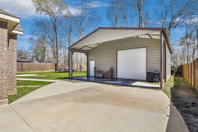 detached garage with concrete driveway and fence