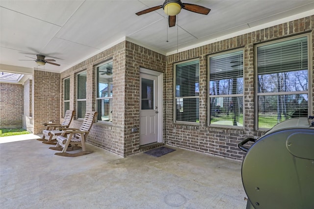 property entrance featuring brick siding and ceiling fan