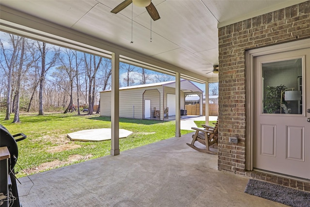 view of patio / terrace featuring an outbuilding, a ceiling fan, and fence