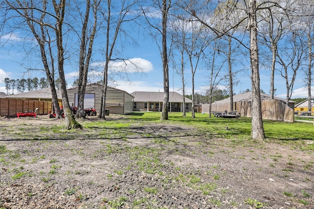 view of yard featuring an outdoor structure and fence