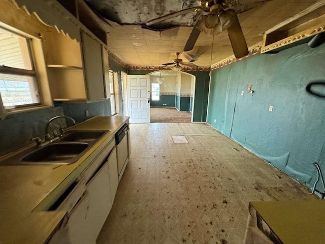 kitchen with dishwashing machine, white cabinets, ceiling fan, and a sink