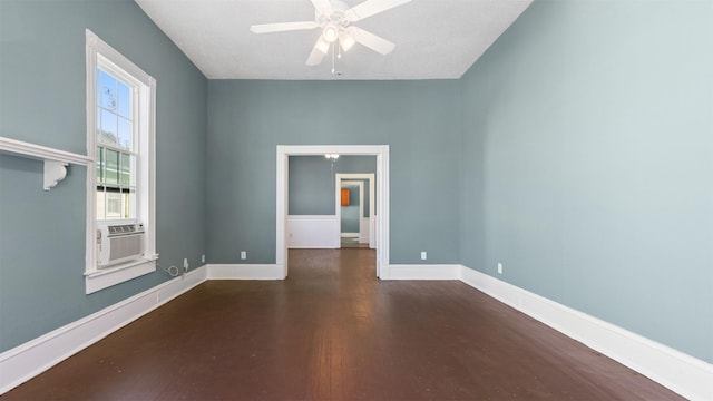 empty room featuring cooling unit, baseboards, ceiling fan, and wood finished floors