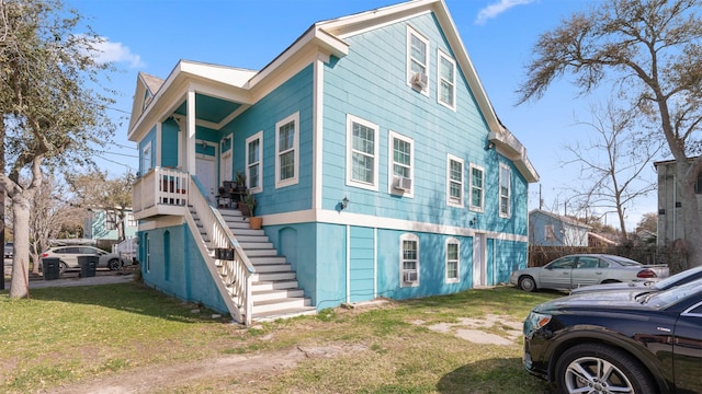 view of property exterior with stairway and a lawn