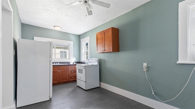 kitchen featuring brown cabinets, white appliances, a ceiling fan, and a sink