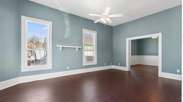 spare room with cooling unit, baseboards, wood finished floors, and a ceiling fan