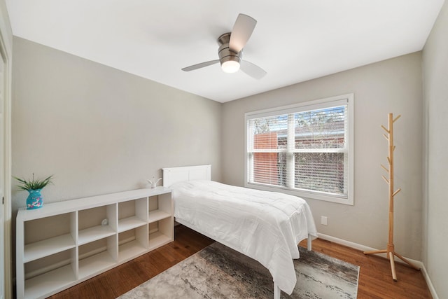 bedroom featuring baseboards, dark wood finished floors, and a ceiling fan